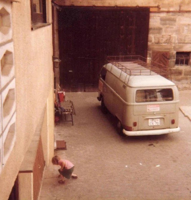 Der erste VW-Bus des Betriebs vor einem Scheunentor, verblichenes Farbfoto