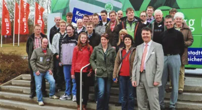 Die Belegschaft vor grünen Messefahnen